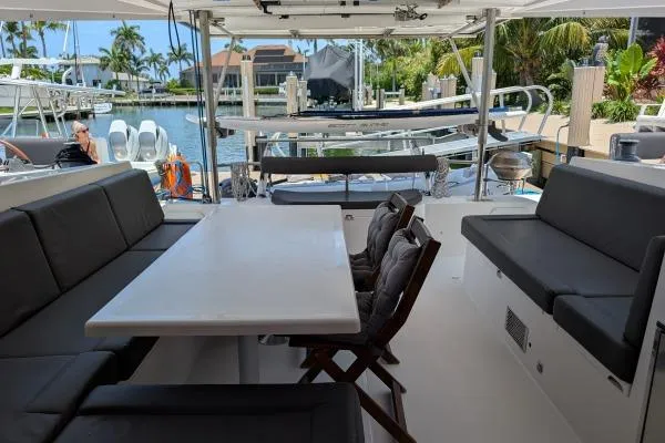 Slide: The Image of Spacious deck of 2016 Nautitech 40 Open catamaran with seating and table, docked by waterfront. - 23