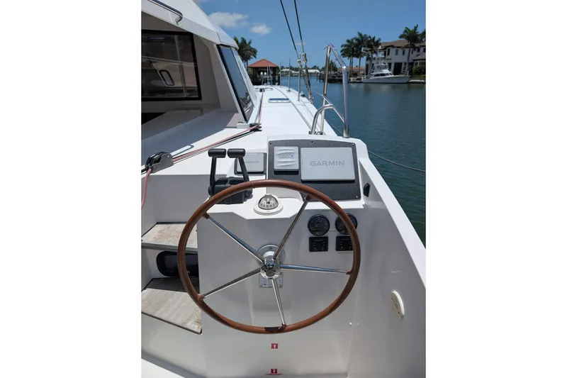 Slide: The Image of Helm of 2016 Nautitech 40 Open catamaran with Garmin navigation system, docked by waterfront homes. - 26