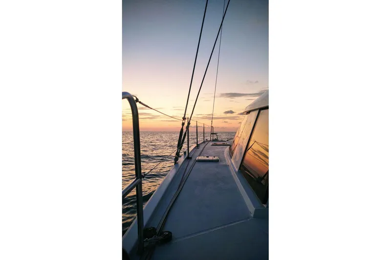Slide: The Image of Sailing on a 2016 Nautitech 40 Open catamaran at sunset over calm ocean waters. - 30