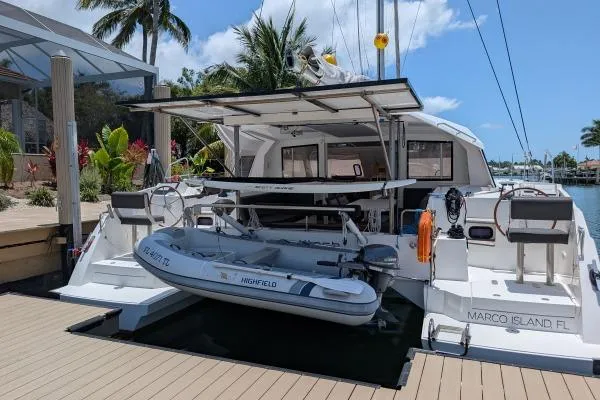 Slide: The Image of Nautitech 40 Open 2016 catamaran docked at Marco Island, featuring a dinghy and tropical backdrop. - 39