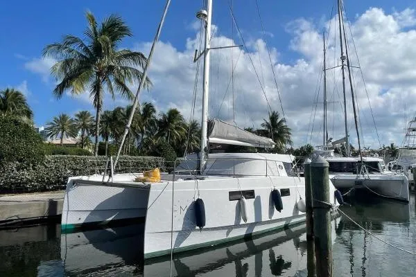 Slide: The Image of 2016 Nautitech 40 Open catamaran docked, surrounded by palm trees and clear skies. - 4