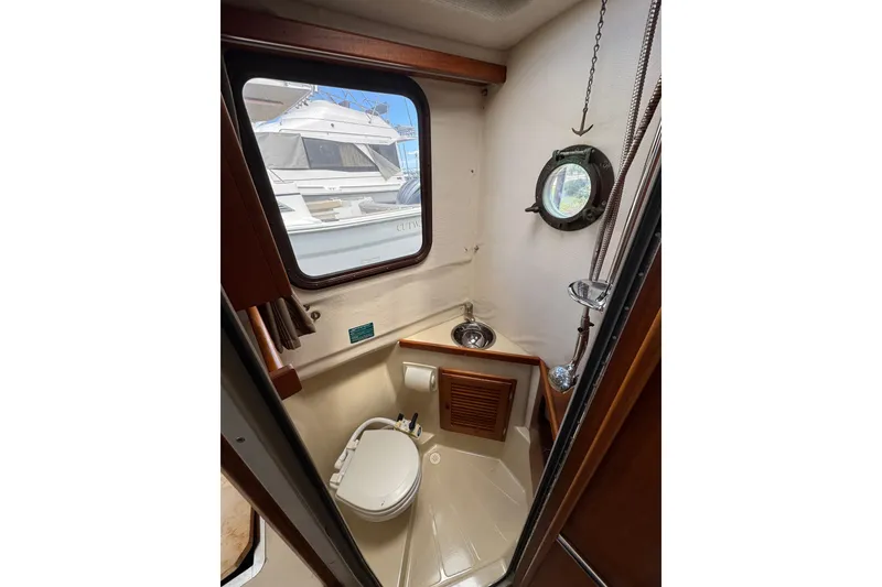 Slide: The Image of 2008 Ranger Tugs R-25 Classic boat bathroom with porthole and compact design. - 12