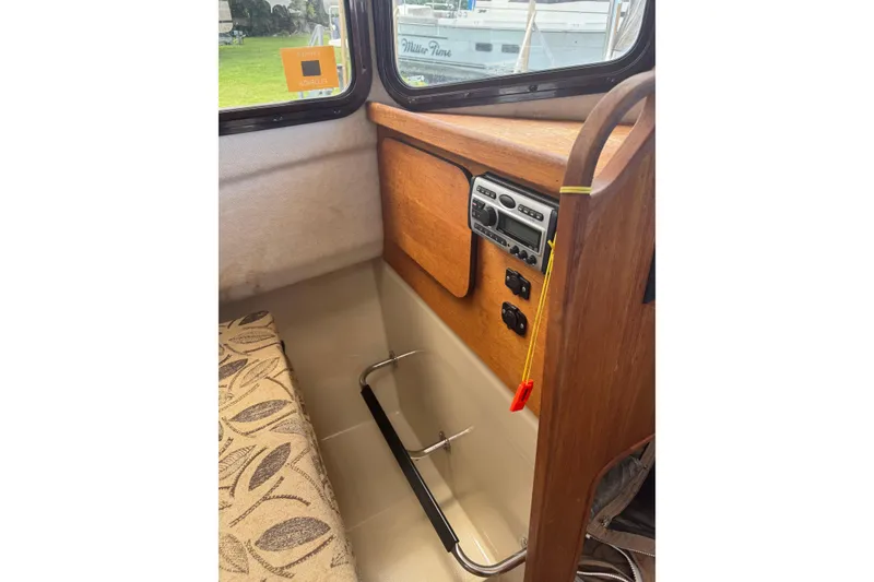 Slide: The Image of 2008 Ranger Tugs R-25 Classic interior with wood paneling and control panel. - 17