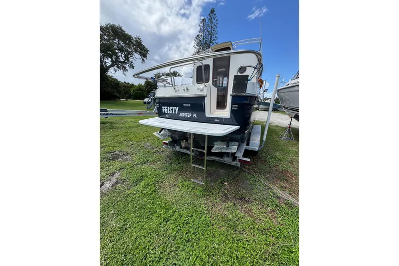 Slide: The Image of 2008 Ranger Tugs R-25 Classic boat on trailer, grassy area, blue sky background. - 3