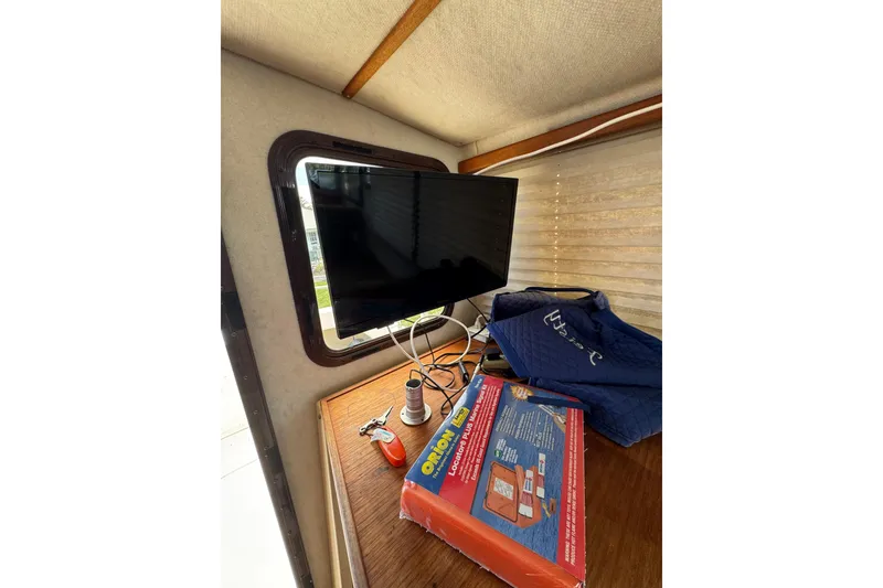 Slide: The Image of 2008 Ranger Tugs R-25 Classic interior with TV, window, and boating equipment. - 7