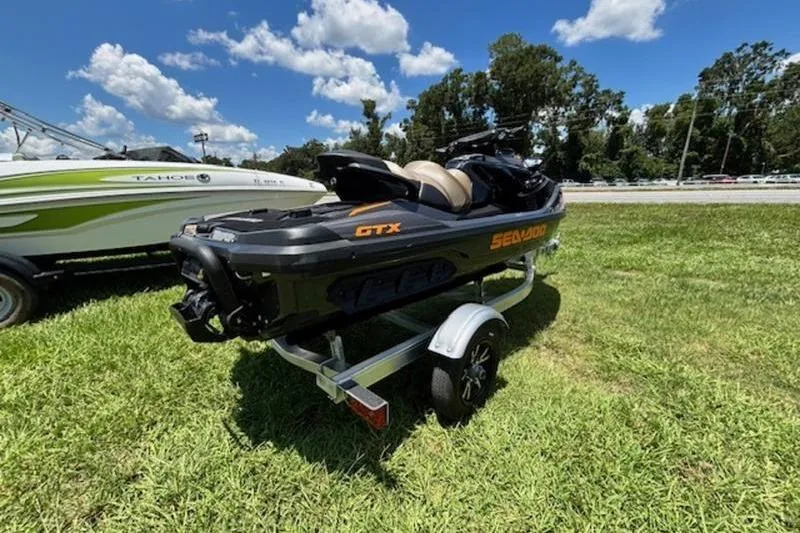 Slide: The Image of 2023 Sea-Doo GTX 170 on trailer, parked on grass under a clear blue sky. - 3
