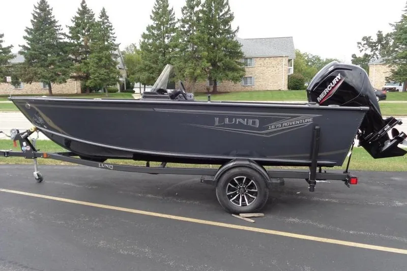 The Image of 2026 Lund 1675 Adventure SS boat on trailer, parked outdoors. - 0