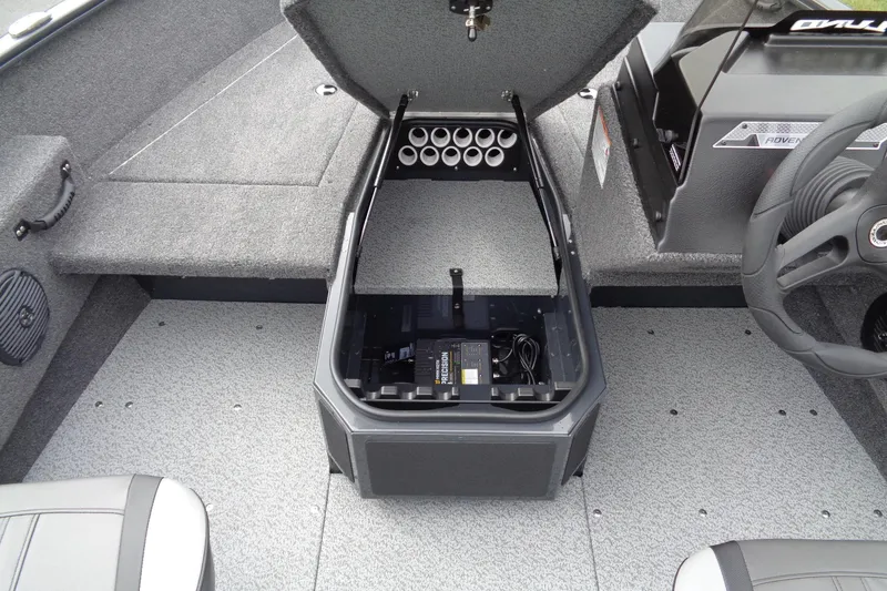 Slide: The Image of 2026 Lund 1675 Adventure SS boat interior with open storage compartment and steering wheel. - 16