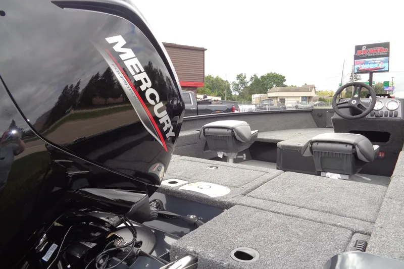 Slide: The Image of 2026 Lund 1675 Adventure SS boat interior with Mercury engine, featuring seating and steering console. - 5