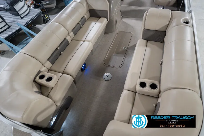 Slide: The Image of 2020 Sun Tracker Party Barge 24 DLX interior with beige seating and cup holders. - 12