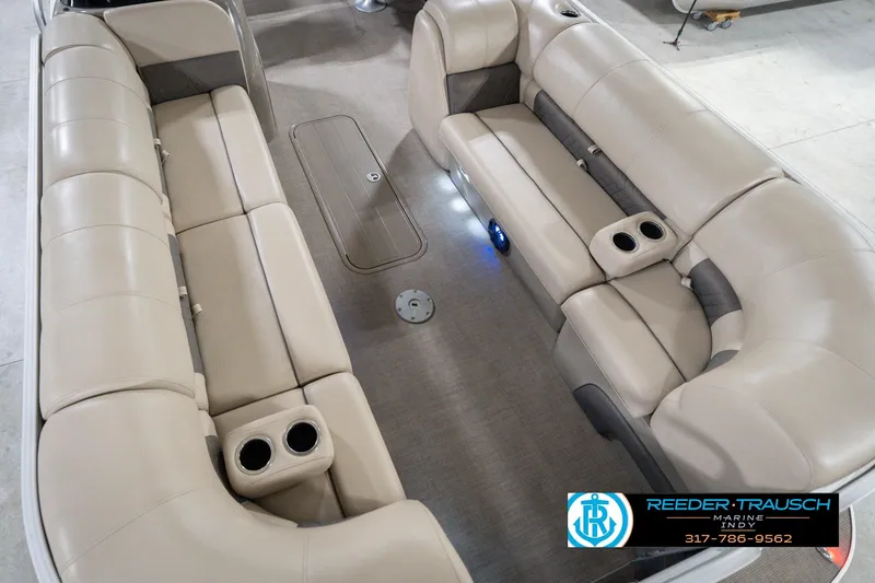 Slide: The Image of 2020 Sun Tracker Party Barge 24 DLX interior with beige seating and cup holders. - 13