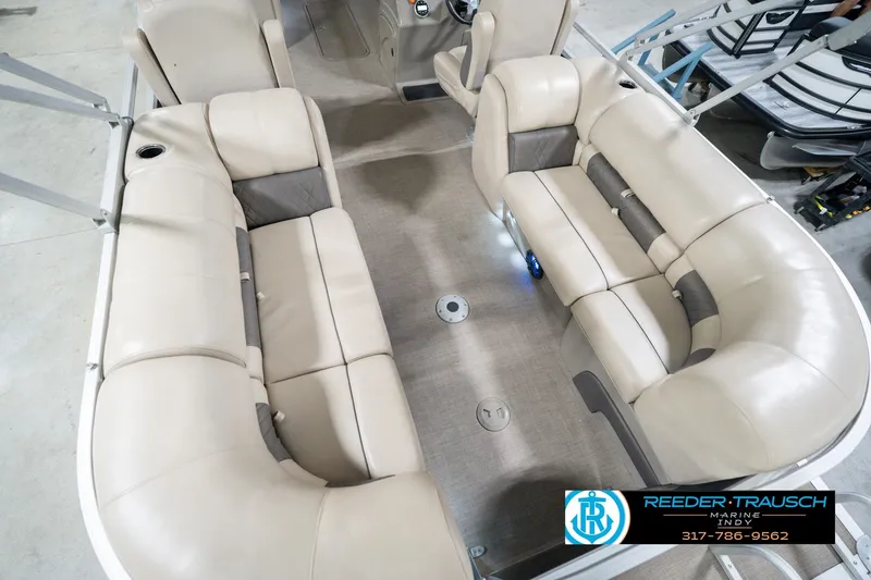 Slide: The Image of 2020 Sun Tracker Party Barge 24 DLX interior with beige seating and cup holders. - 15