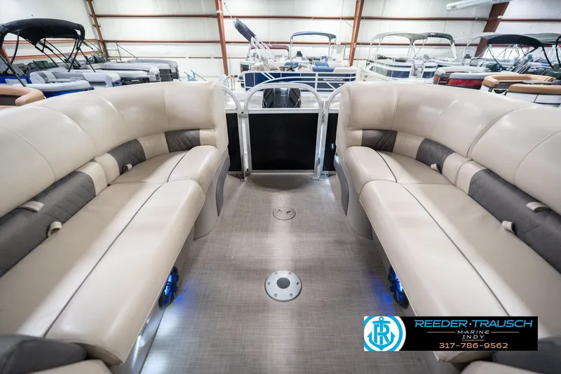 Slide: The Image of 2020 Sun Tracker Party Barge 24 DLX interior with beige seating in a showroom. - 18