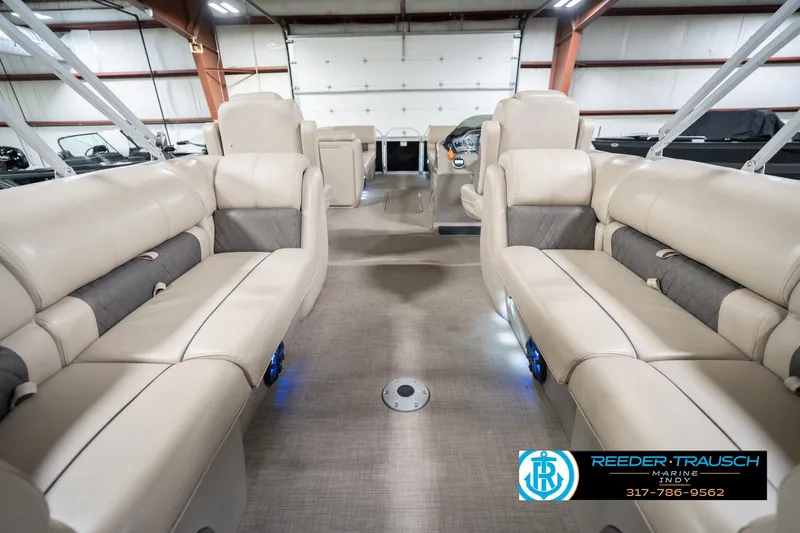 Slide: The Image of 2020 Sun Tracker Party Barge 24 DLX interior with beige seating in a showroom. - 19