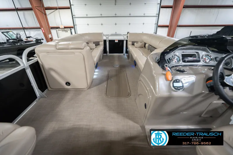 Slide: The Image of 2020 Sun Tracker Party Barge 24 DLX interior with beige seating and control panel. - 20
