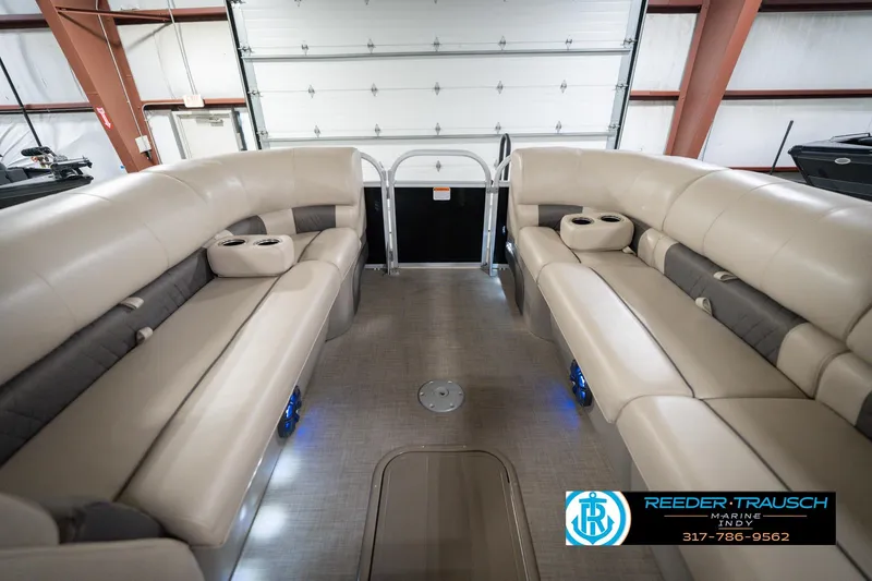 Slide: The Image of 2020 Sun Tracker Party Barge 24 DLX interior with beige seating and cup holders. - 21