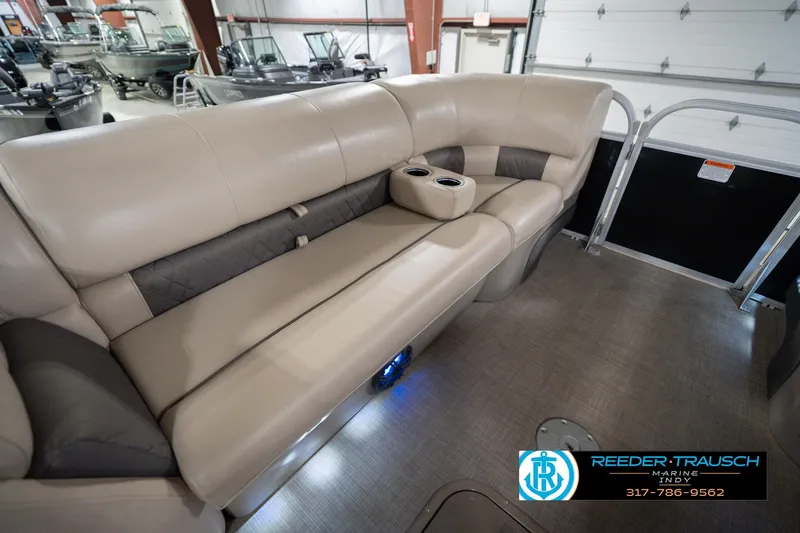 Slide: The Image of 2020 Sun Tracker Party Barge 24 DLX interior with beige seating and cup holders. - 22