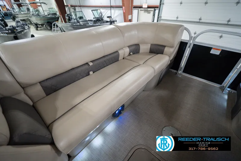 Slide: The Image of 2020 Sun Tracker Party Barge 24 DLX interior with beige seating in showroom. - 23