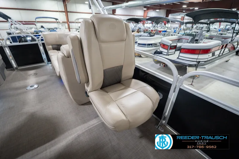 Slide: The Image of 2020 Sun Tracker Party Barge 24 DLX interior with beige seating in showroom. - 26