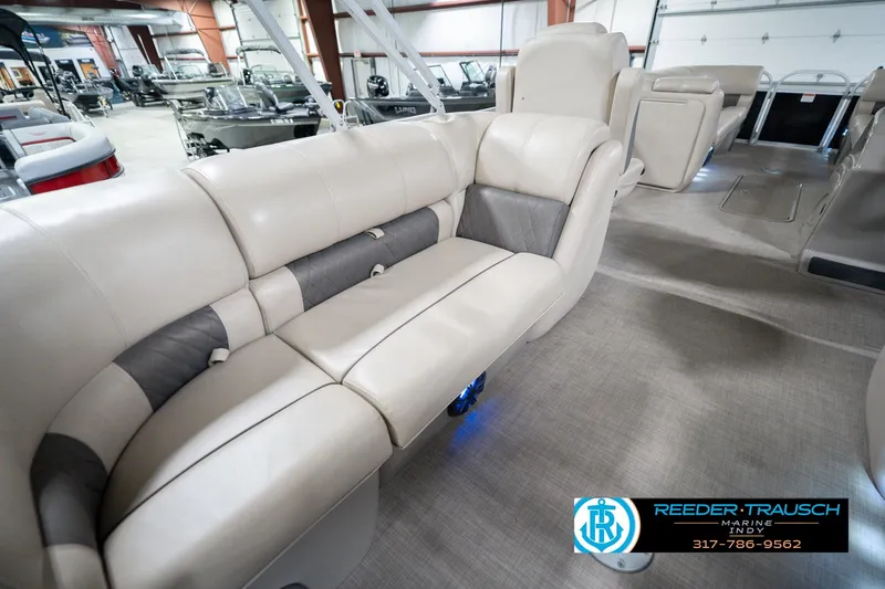 Slide: The Image of 2020 Sun Tracker Party Barge 24 DLX interior with beige seating in showroom. - 30