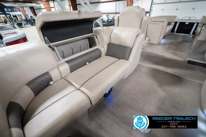 Slide: The Image of 2020 Sun Tracker Party Barge 24 DLX interior with beige seating and storage compartment. - 33
