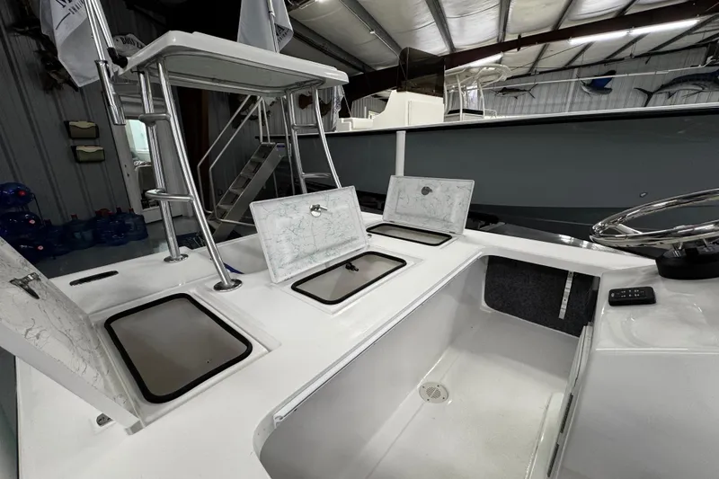 Slide: The Image of 2026 Mitzi Skiffs 17 Tournament boat interior in showroom with seating and steering console. - 12