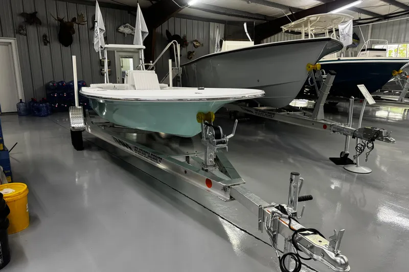 Slide: The Image of 2026 Mitzi Skiffs 17 Tournament boat on trailer in showroom. - 2
