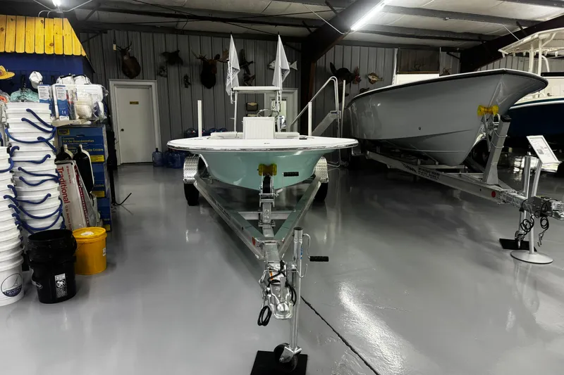 Slide: The Image of 2026 Mitzi Skiffs 17 Tournament boat in showroom, surrounded by equipment and supplies. - 3