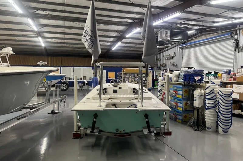 Slide: The Image of 2026 Mitzi Skiffs 17 Tournament boat displayed in a showroom with flags and trailers. - 6