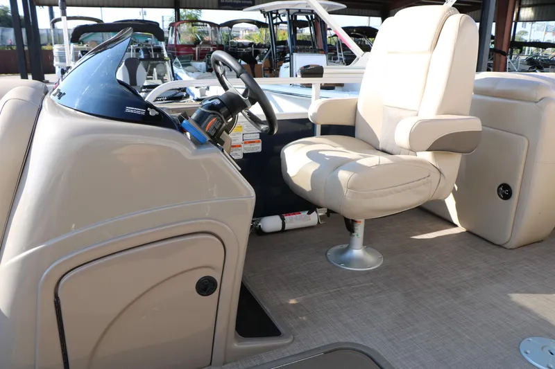 Slide: The Image of 2022 Sun Tracker Party Barge 22 RF XP3 helm with beige captain's chair and steering console. - 22