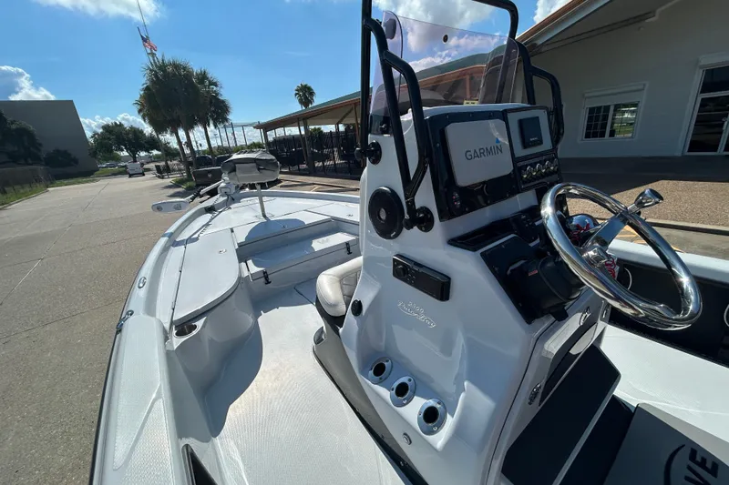 Slide: The Image of 2018 Blue Wave 2300 PureBay boat with Garmin navigation, docked under sunny skies. - 13