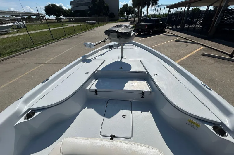 Slide: The Image of 2018 Blue Wave 2300 PureBay boat, parked outdoors, showcasing spacious deck and seating area. - 15