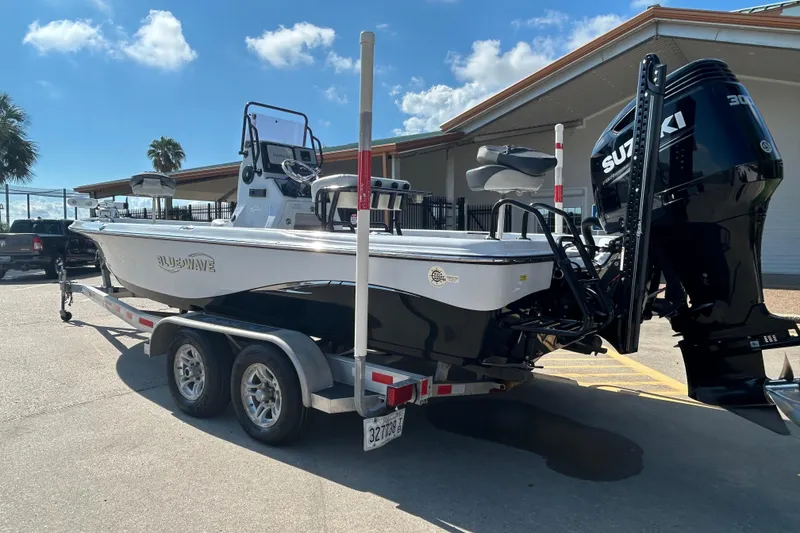 Slide: The Image of 2018 Blue Wave 2300 PureBay boat on trailer with Suzuki engine, parked outdoors. - 3