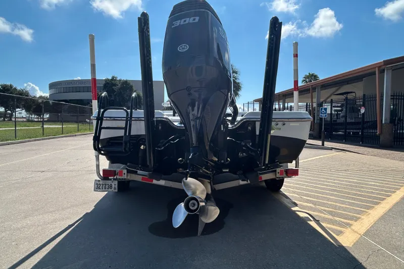 Slide: The Image of 2018 Blue Wave 2300 PureBay boat with powerful outboard motor, parked outdoors. - 6