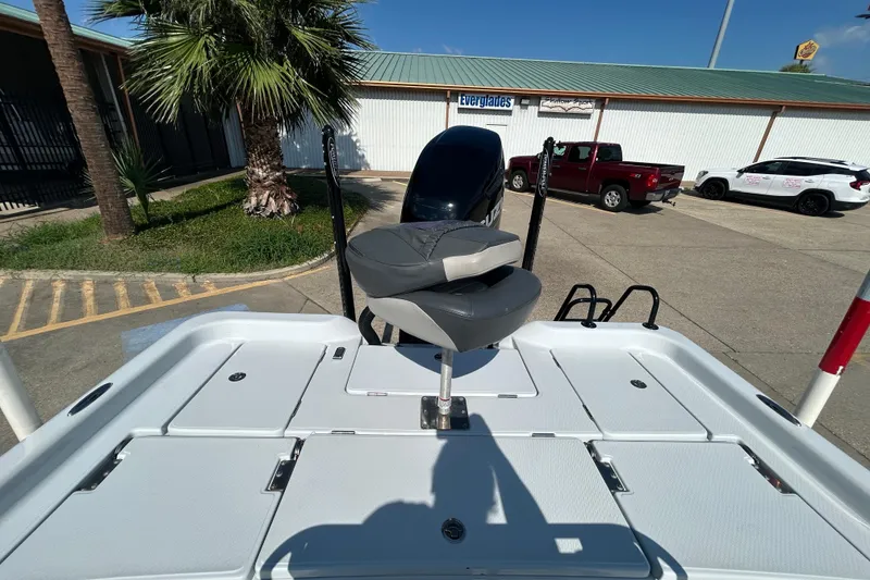 Slide: The Image of 2018 Blue Wave 2300 PureBay boat with seating, parked near palm trees and vehicles. - 9