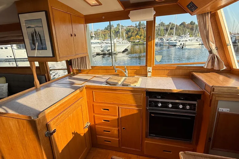 Slide: The Image of 1988 Grand Banks Heritage CL yacht kitchen with wood cabinetry and marina view. - 21
