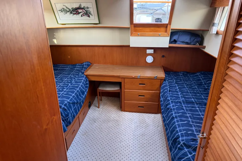 Slide: The Image of 1988 Grand Banks Heritage CL cabin with twin beds, wooden desk, and nautical decor. - 22