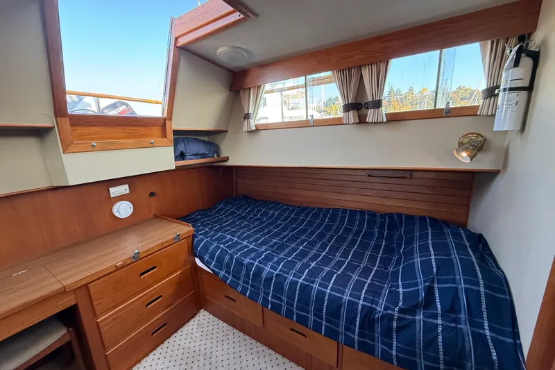 Slide: The Image of Cozy cabin interior of 1988 Grand Banks Heritage CL with wood finish and blue bedding. - 28