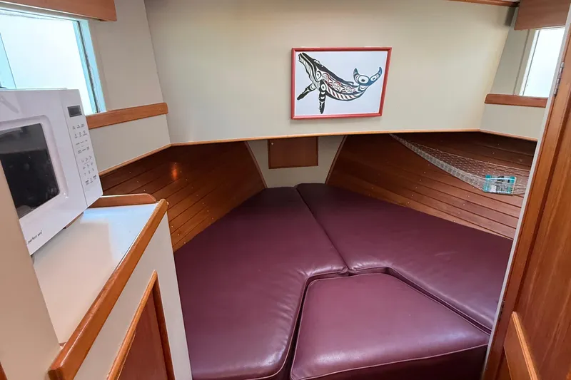 Slide: The Image of Cozy cabin interior of 1988 Grand Banks Heritage CL with maroon cushions and artwork. - 35