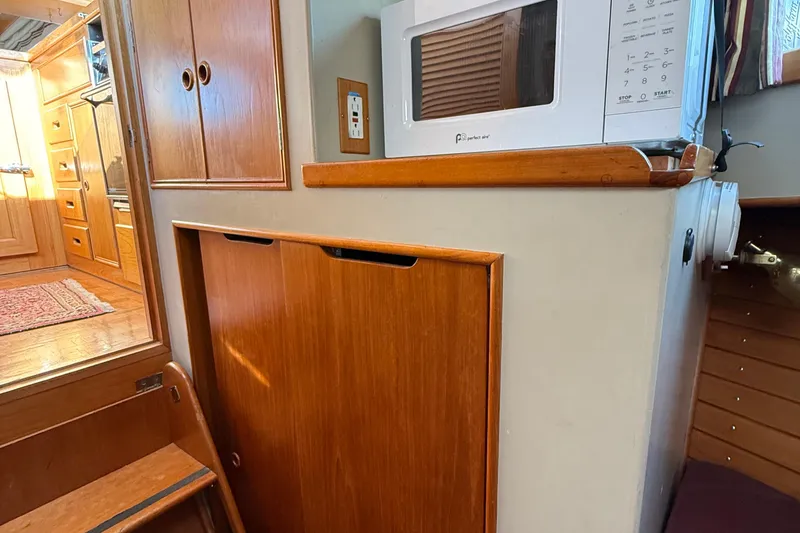 Slide: The Image of 1988 Grand Banks Heritage CL interior with wooden cabinetry and microwave. - 36