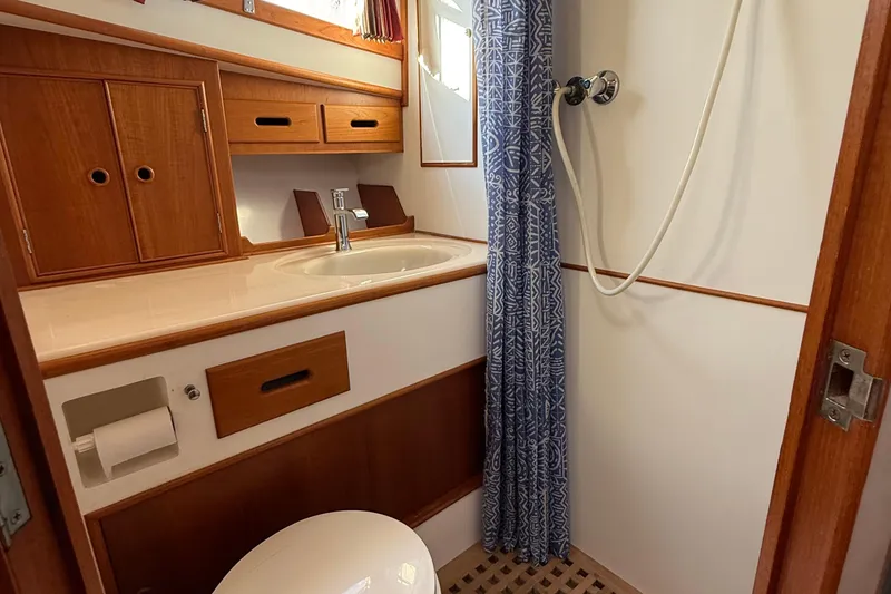 Slide: The Image of 1988 Grand Banks Heritage CL bathroom with wooden cabinetry, sink, and shower curtain. - 37