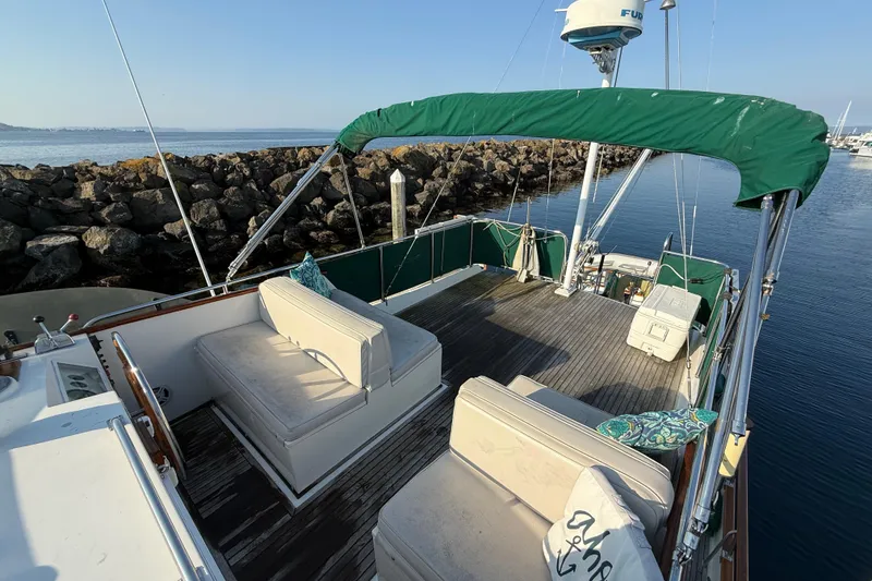 Slide: The Image of 1988 Grand Banks Heritage CL yacht deck with seating, green canopy, and ocean view. - 38