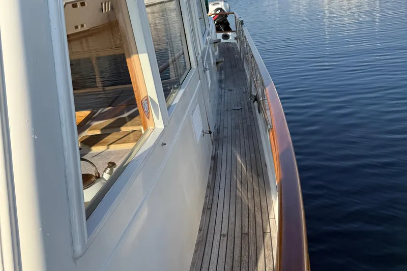 Slide: The Image of 1988 Grand Banks Heritage CL yacht deck with wooden railings and calm water reflection. - 40
