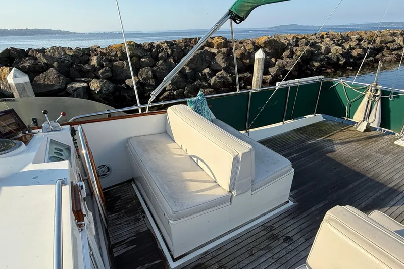 Slide: The Image of 1988 Grand Banks Heritage CL yacht deck with seating, overlooking rocky shoreline. - 44