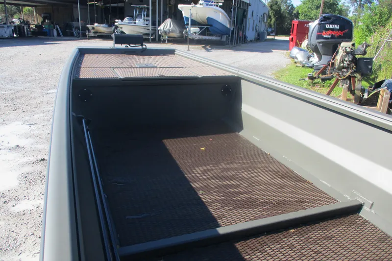 Slide: The Image of 2026 Gator Tail 1748 Gator Series boat interior with metal flooring, parked outdoors. - 5