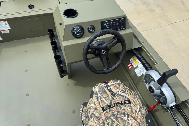 Slide: The Image of 2026 Lund 1760 Predator SC boat interior with camouflage seats and steering console. - 5
