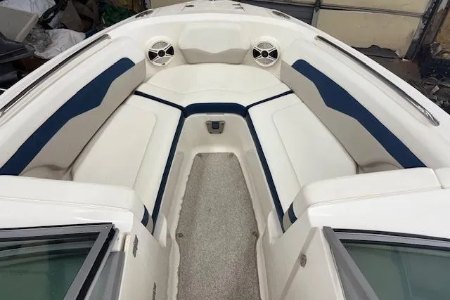 Slide: The Image of 2011 Chaparral 226 SSi boat interior with white and blue seating, speakers, and carpeted floor. - 4