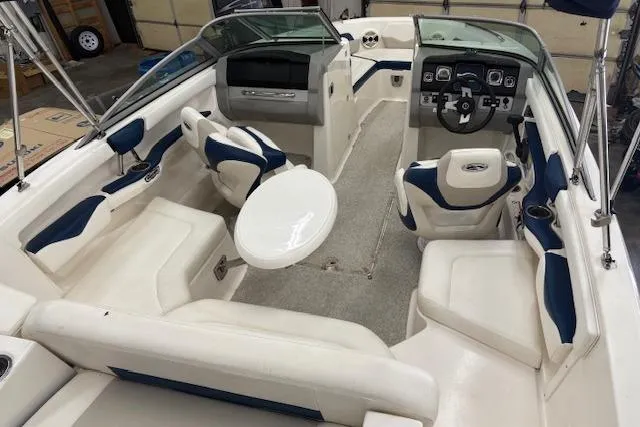 Slide: The Image of 2011 Chaparral 226 SSi boat interior with white and blue seating, steering wheel, and table. - 5