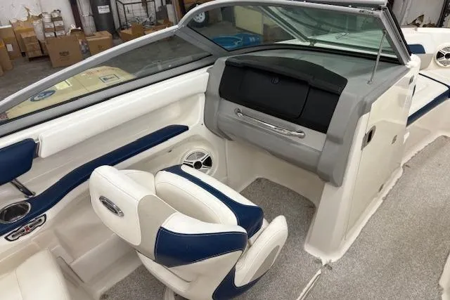 Slide: The Image of 2011 Chaparral 226 SSi boat interior with white and blue seating, dashboard, and carpeted floor. - 9