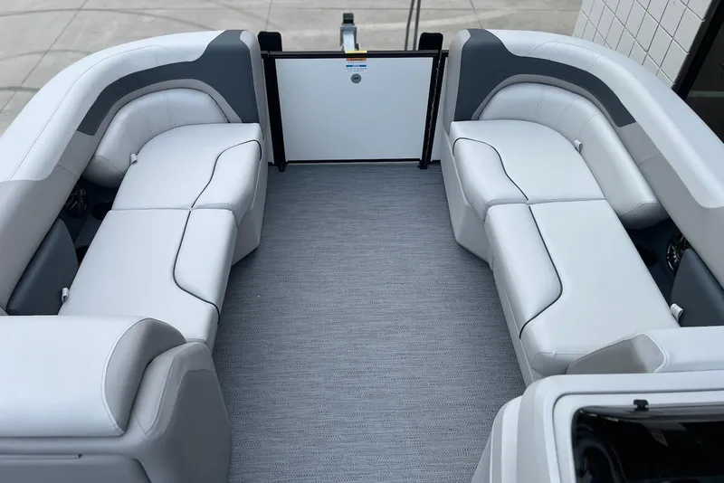 Slide: The Image of 2026 Godfrey Sweetwater 2086 SB boat interior with white seating and gray flooring. - 9